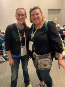 Two women standing next to each other in a room.