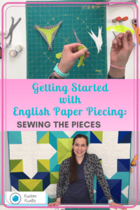 A woman is sewing paper pieces on the wall.