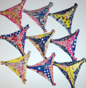 A group of nine colorful triangle shaped fabric pieces.