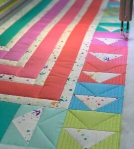 A colorful quilt with many different colors and designs.