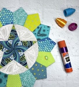 Colorful paper shapes and a glue stick for crafting.