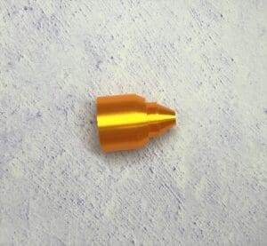 A close up of an orange bullet on the ground