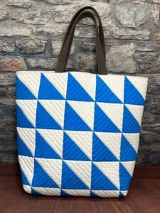 A blue and white bag sitting on top of a wooden floor.