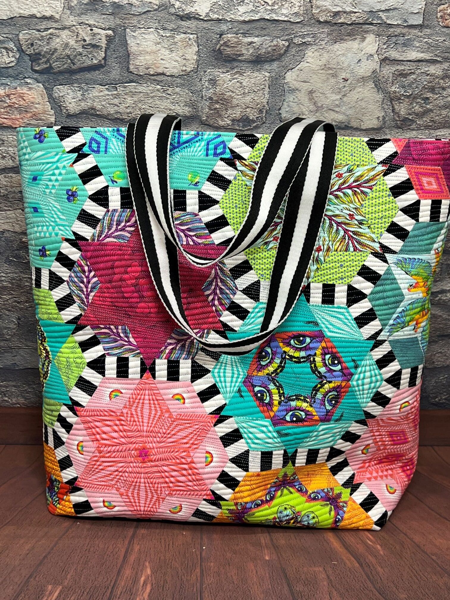 A colorful bag with black and white stripes on the bottom.