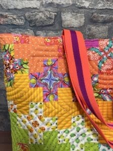 A close up of the shoulder strap on a quilted bag