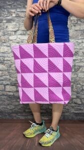 A person holding onto a bag with purple squares
