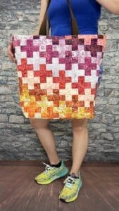 A person standing in front of a brick wall.
