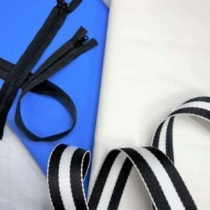 A pair of zippers and a ribbon on top of a table.