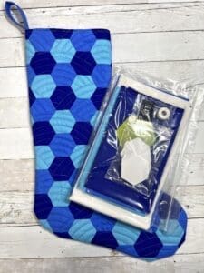 A blue sock with a cell phone inside of it.
