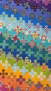 A close up of a quilt with different colors