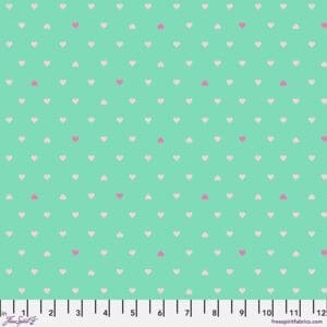 A green background with white and pink polka dots.