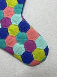A colorful quilt is shown on the floor.