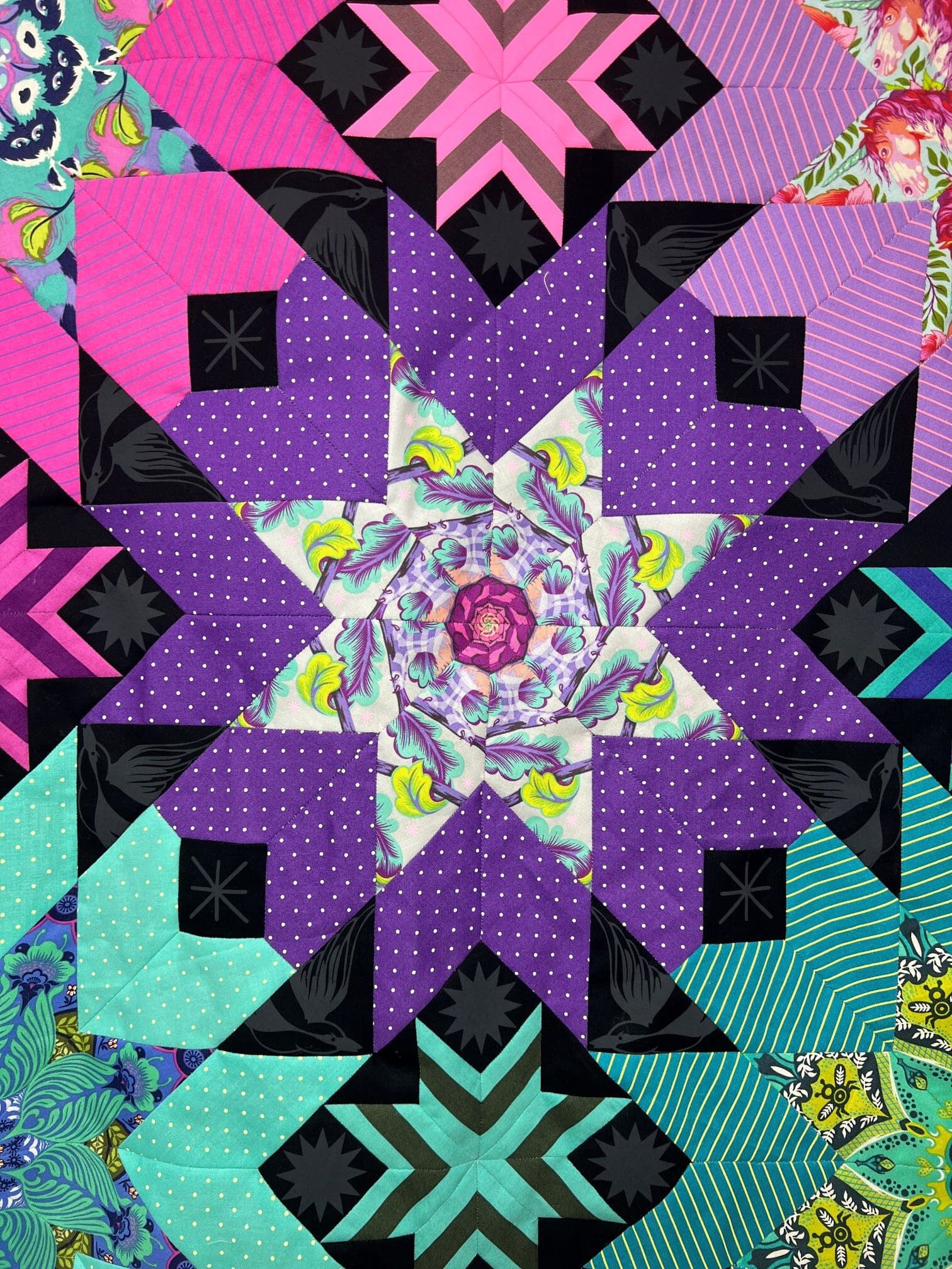 A colorful quilt with a star design in the center.