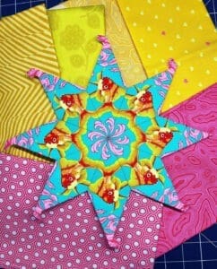 A colorful star quilt with different colored fabrics.