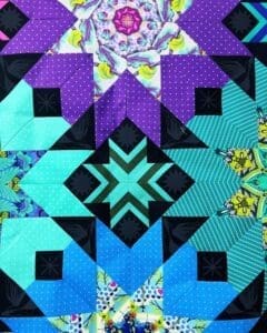 A quilt with different colored squares and designs.