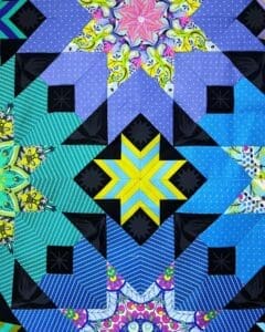 A quilt with blue and yellow designs on it.