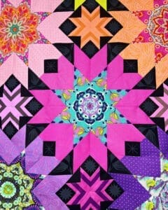 A colorful quilt with a star design in the center.