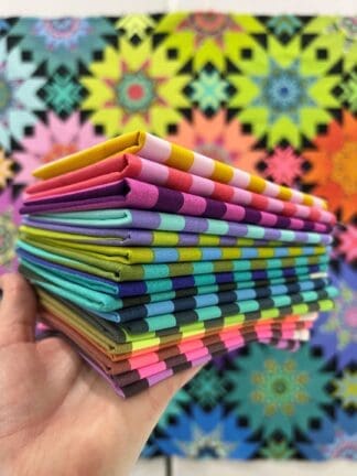 A stack of folded paper in front of a colorful background.