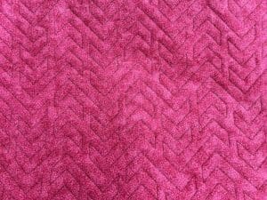 Close-up of a textured pink fabric with a chevron pattern.