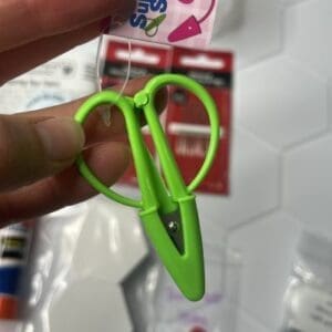 Green plastic clip held between fingers.