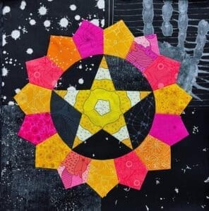 Colorful rangoli design with a star and flower patterns on a black surface.