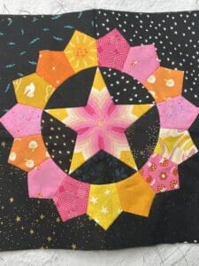 Colorful hexagon quilt pattern with a star design in the center.