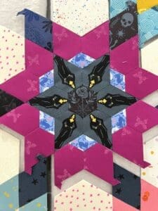 Intricate star-shaped quilt block with geometric patterns and contrasting colors.