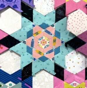Colorful geometric quilt pattern with stars and hexagons.